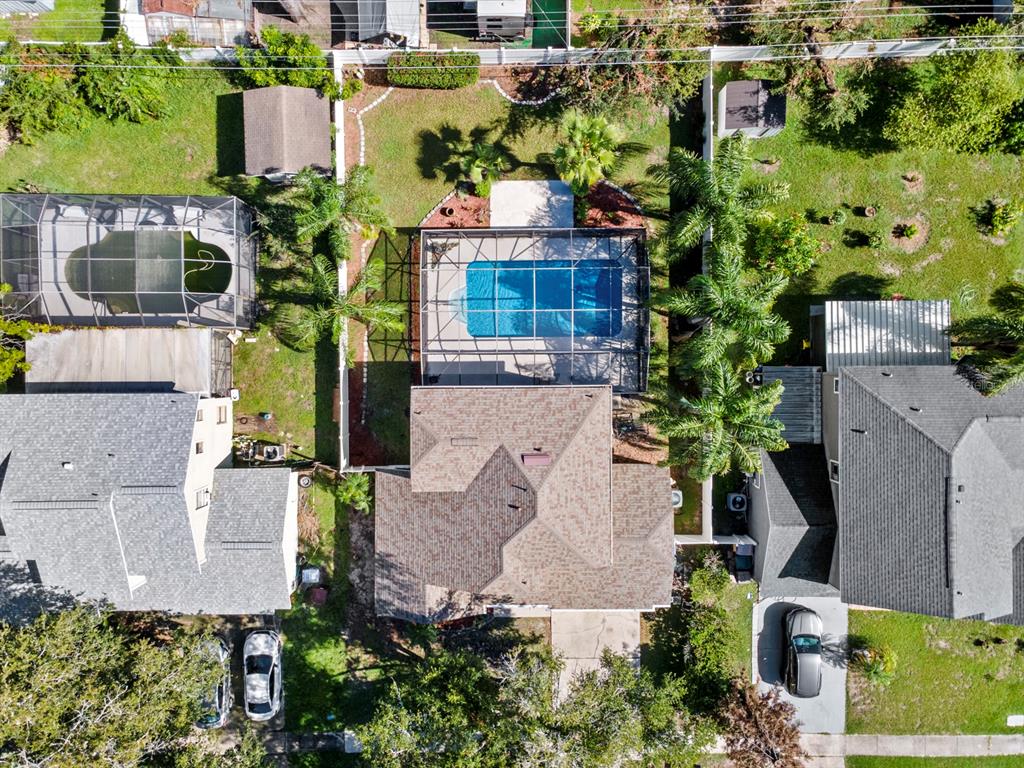 An aerial view shows a house with a screened-in pool and a fenced backyard — 1461 AMANDA ROAD, KISSIMMEE, FL