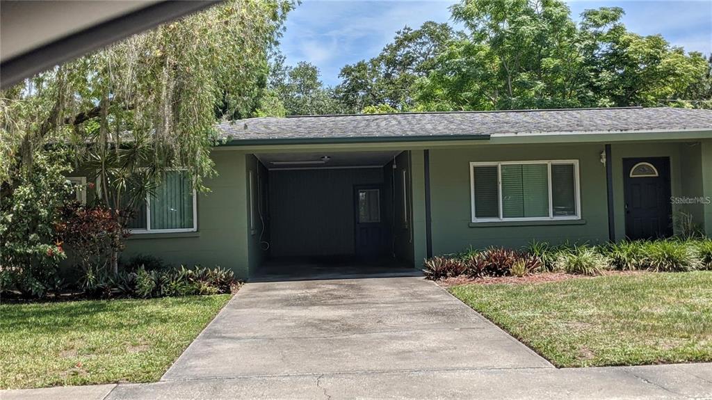 A single-story house with a green exterior, a central carport, and a concrete driveway — 2104 PALM TERRACE, SARASOTA, FL