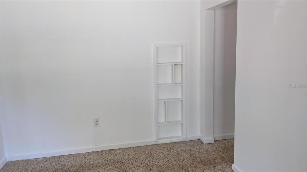 A room with beige carpet, white walls, and a built-in white shelving unit — 2104 PALM TERRACE, SARASOTA, FL