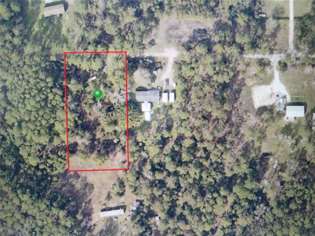 An aerial view shows a rectangular plot of land outlined in red with dense vegetation — 4650 HERIN DRIVE, NEW SMYRNA BEACH, FL