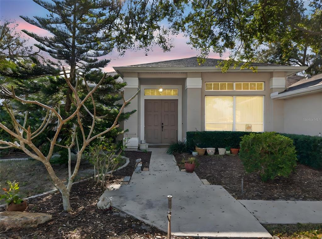The exterior of a single-story house features a double front door and a concrete walkway — 4478 PRO AM AVENUE E, BRADENTON, FL