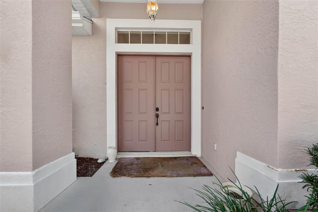 A front entryway features double doors with a transom window and a concrete porch — 4478 PRO AM AVENUE E, BRADENTON, FL