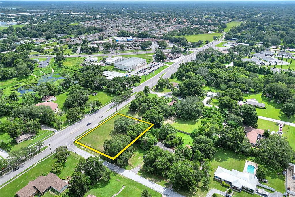 An aerial view shows a vacant, rectangular lot outlined in yellow along a paved road — 703 E LUMSDEN ROAD, BRANDON, FL