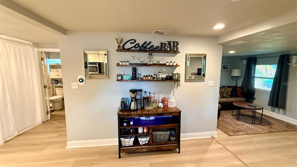 A dining area and living space feature wood-look flooring, a dark wood table, and blue lighting — 313 TAKOMA STREET, ORLANDO, FL