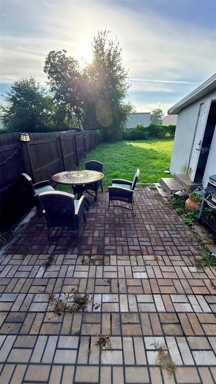 A fenced backyard with a grassy lawn and a detached garage under a blue sky — 313 TAKOMA STREET, ORLANDO, FL