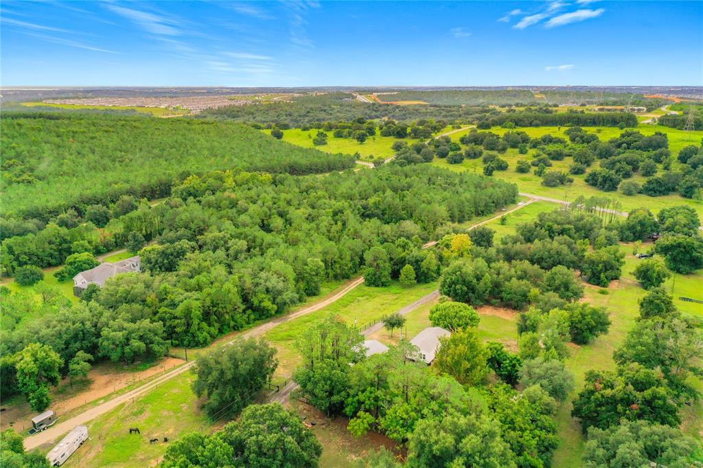 An aerial view shows a rural property with two houses surrounded by trees and pastures — 13131 COUNTY ROAD 561A, CLERMONT, FL