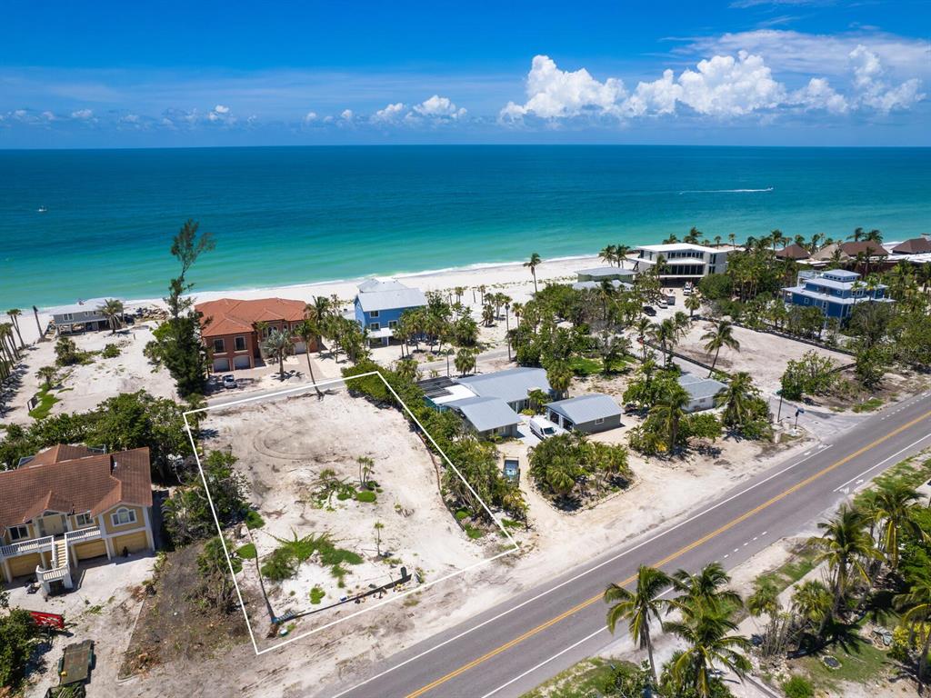 An aerial view shows a vacant beachfront lot outlined in white next to existing houses — 6549 GULF OF MEXICO DRIVE, LONGBOAT KEY, FL