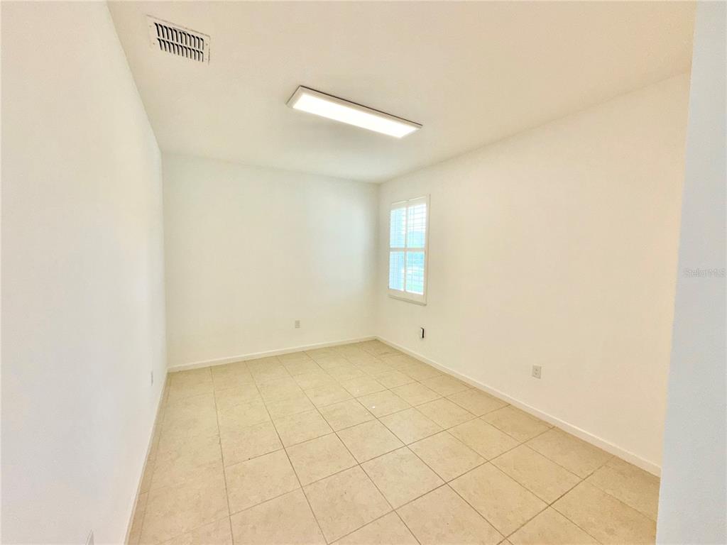 An empty room with white walls, tile flooring, a window with shutters, and a ceiling light — 2240 RUSH BAY WAY, ORLANDO, FL