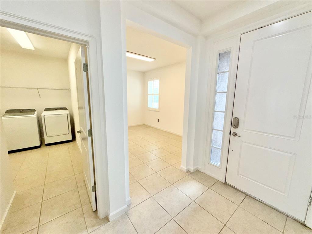 A tiled entryway leads to a laundry room on the left and an adjacent room — 2240 RUSH BAY WAY, ORLANDO, FL