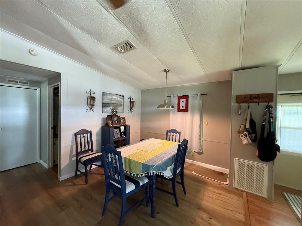 A kitchen features light-colored cabinets, wood-look flooring, a white refrigerator, and a wood countertop — 101 CYPRESS ROAD, WILDWOOD, FL