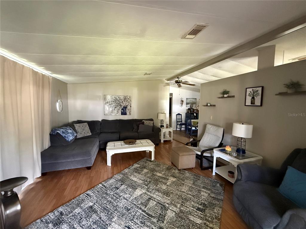 A dining area features a table with chairs, wood-look flooring, and a light-colored wall — 101 CYPRESS ROAD, WILDWOOD, FL