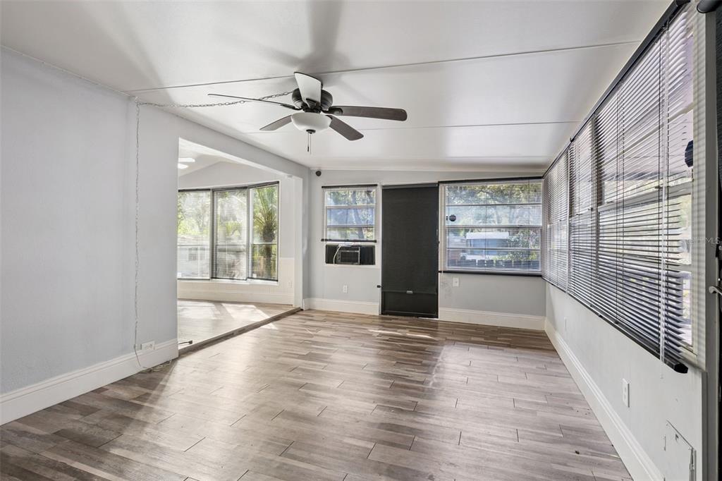 A sunroom with wood-look flooring, a ceiling fan, and large windows with horizontal blinds — 3000 CLARCONA ROAD UNIT 767, APOPKA, FL