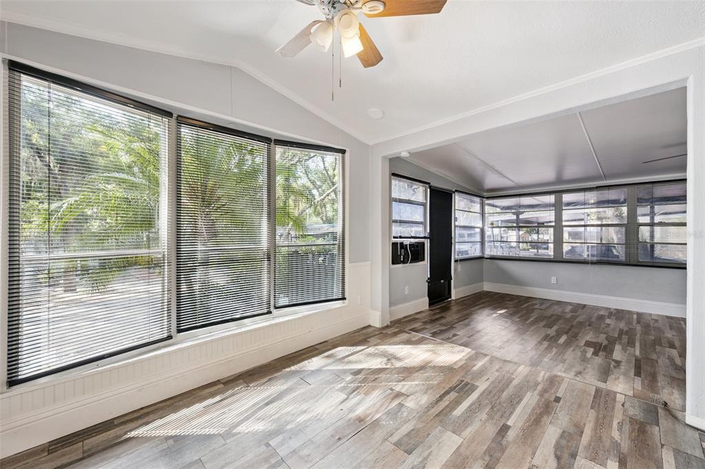 A bright room with wood-look flooring, large windows with blinds, and a ceiling fan — 3000 CLARCONA ROAD UNIT 767, APOPKA, FL