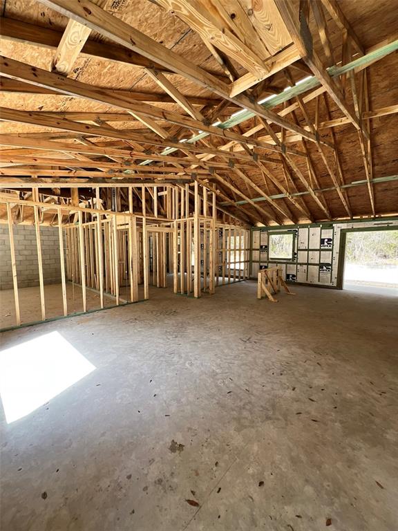 An interior view of a house under construction with exposed wood framing and concrete floors — 3 GUAVA PASS RUN, OCKLAWAHA, FL