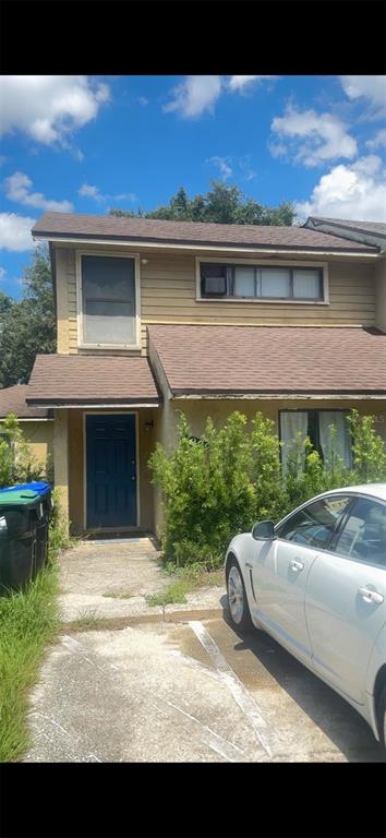 A two-story tan house with a blue front door and a white car parked outside — 1299 WOODMAN WAY UNIT 1, ORLANDO, FL