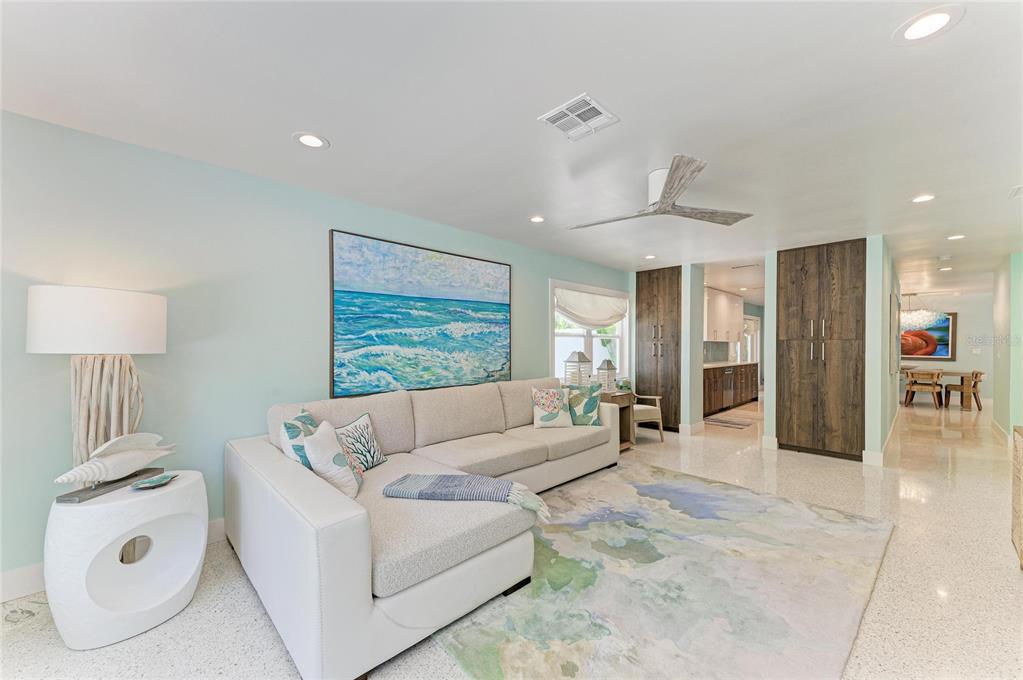 A living room features a white sectional sofa, a coastal-themed rug, and tall wood cabinets — 580 LINLEY STREET, LONGBOAT KEY, FL