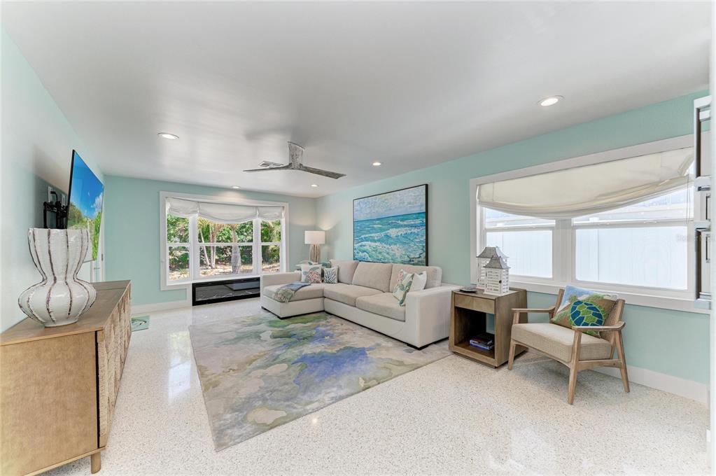A light blue house with a palm tree in the yard and a paved patio — 580 LINLEY STREET, LONGBOAT KEY, FL