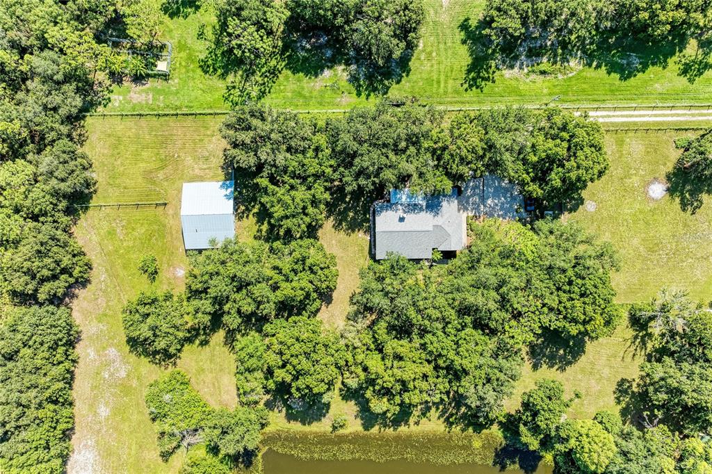 An aerial view shows a house and a detached shed surrounded by trees and grass — 6055 COUNTY ROAD 675, MYAKKA CITY, FL