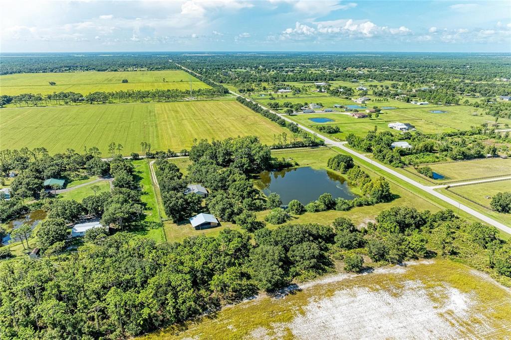 An aerial view shows a rural property with a pond, trees, and several small buildings — 6055 COUNTY ROAD 675, MYAKKA CITY, FL