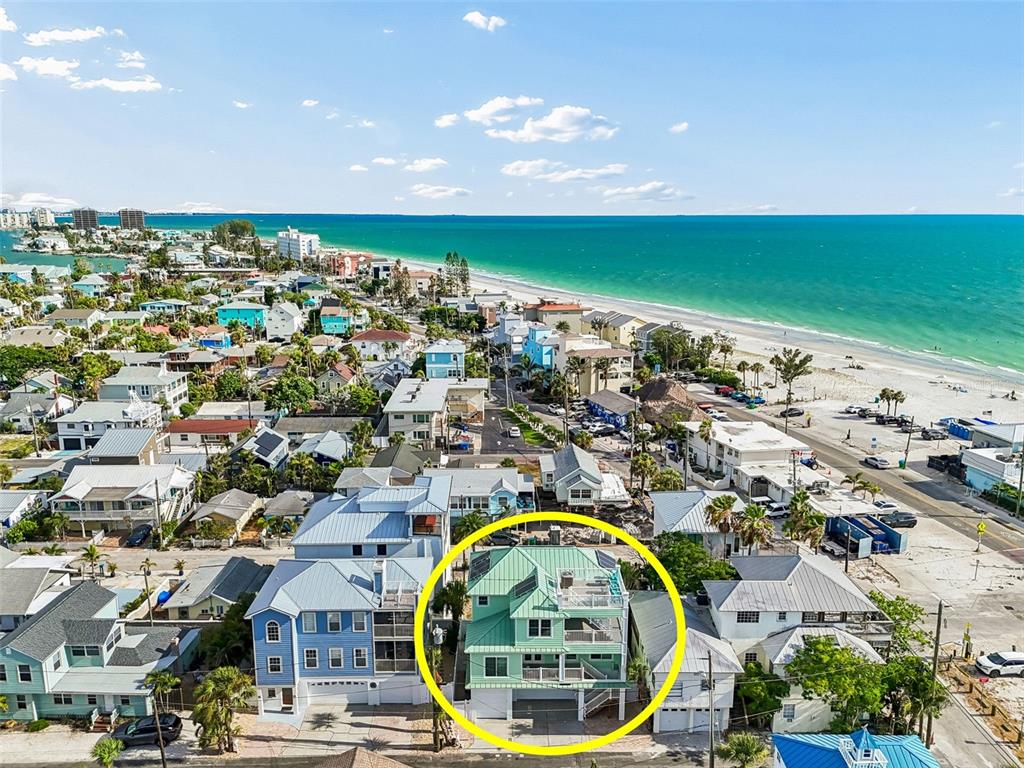 An aerial view shows a coastal neighborhood with houses situated along a sandy beach — 111 91ST AVENUE, TREASURE ISLAND, FL