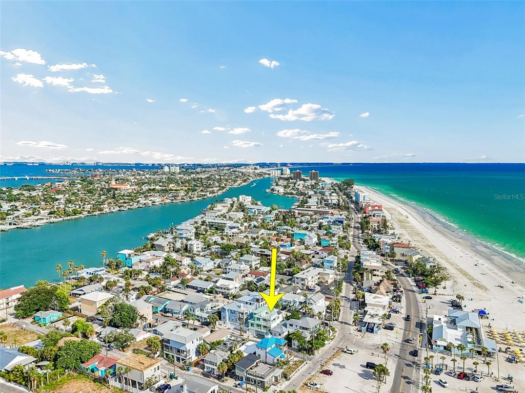 An aerial view shows colorful beach houses near the ocean with a sandy shoreline — 111 91ST AVENUE, TREASURE ISLAND, FL