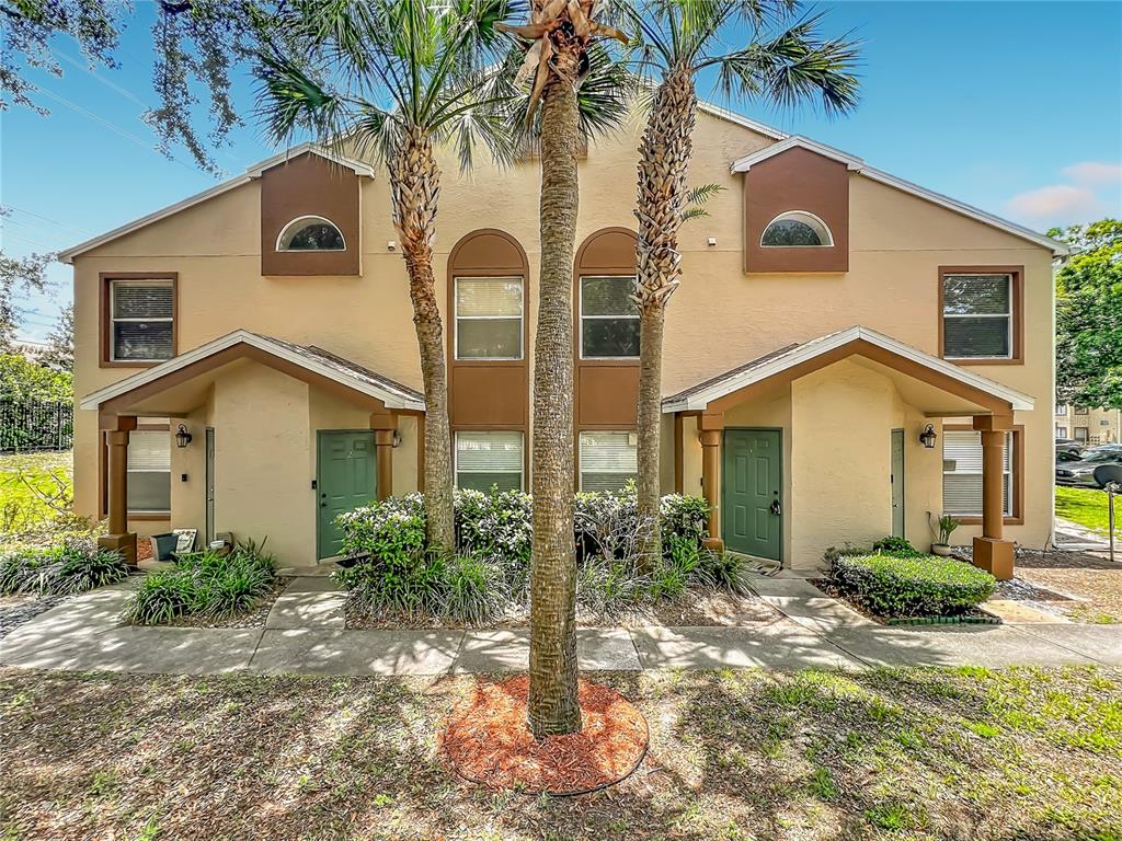 A two-story tan apartment building with a green front door and a covered entryway — 5464 E MICHIGAN STREET UNIT 5464-8, ORLANDO, FL