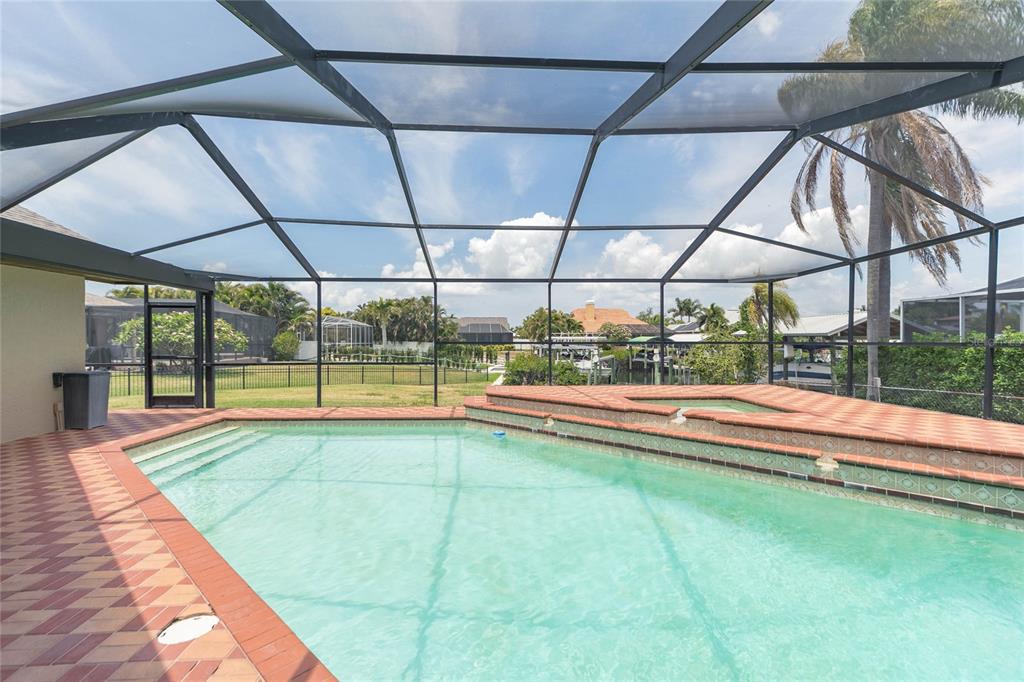 A swimming pool and hot tub enclosed by a screened lanai with brick paver decking — 6602 SEABIRD WAY, APOLLO BEACH, FL