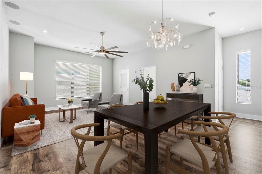 A dining and living area features a dark wood table, orange sofa, and modern chandelier — 4810 W MCELROY AVENUE UNIT 7, TAMPA, FL