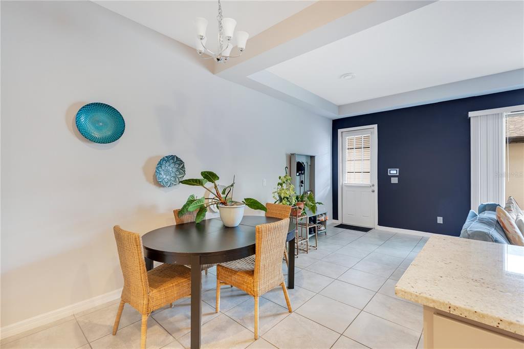 A dining area features a dark oval table, wicker chairs, and a blue accent wall — 5103 JONES ROAD, ST CLOUD, FL