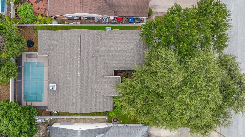An aerial view shows a house with a shingled roof, a screened pool, and large trees — 12965 PINEFOREST WAY W, LARGO, FL