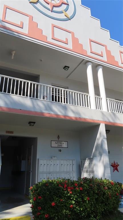 Exterior view of a two-story building with a balcony, white columns, and a decorative facade — 2100 WORLD PARKWAY BOULEVARD UNIT 38, CLEARWATER, FL