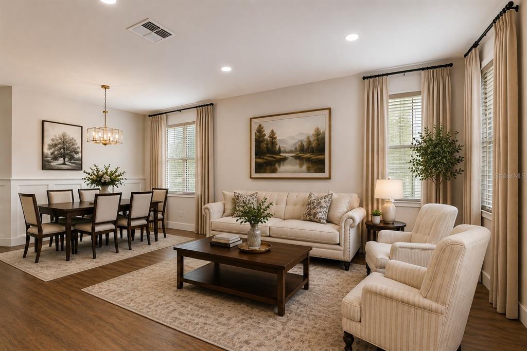 A living and dining room with neutral furniture, wood flooring, and large windows with curtains — 1712 ATLANTIC DRIVE, RUSKIN, FL