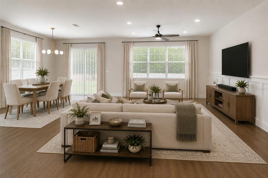 A bright, open-concept living and dining area features neutral furniture, wood flooring, and large windows — 1712 ATLANTIC DRIVE, RUSKIN, FL