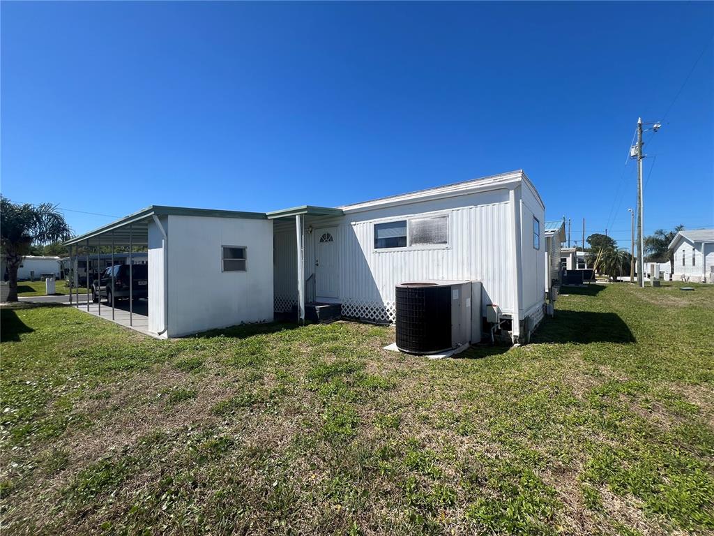 A white mobile home with a carport and an outdoor air conditioning unit — 1500 COUNTY ROAD 1 UNIT 39, DUNEDIN, FL