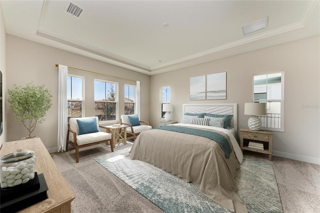 A bedroom features a bed, two armchairs, a rug, and windows with neutral wall paint — 35576 BIG HAWK DRIVE, ZEPHYRHILLS, FL