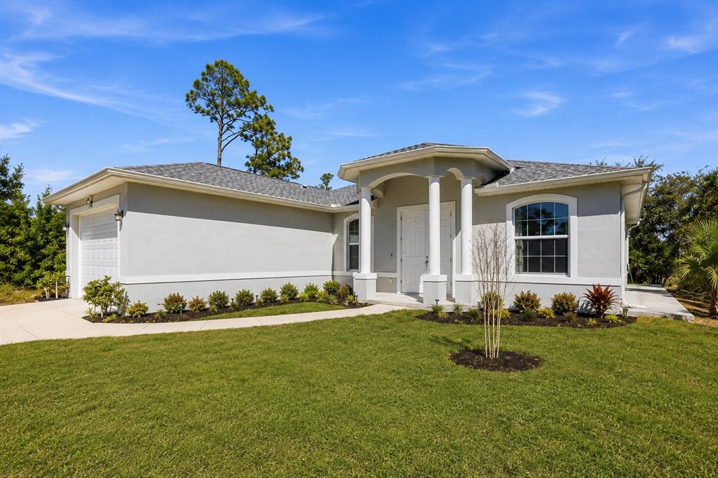 A single-story house with a gray stucco exterior, a two-car garage, and a columned entryway — 3498 DUNKIRK STREET, PORT CHARLOTTE, FL