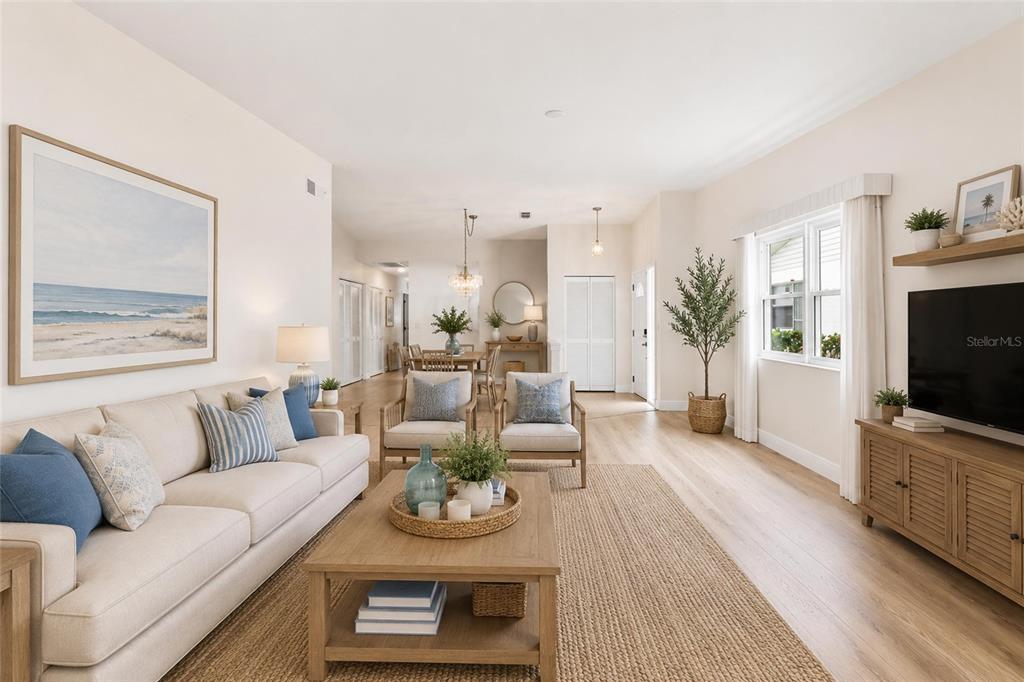 A bright living room features a beige sofa, two armchairs, a coffee table, and television — 3271 MCMATH DRIVE, PALM HARBOR, FL