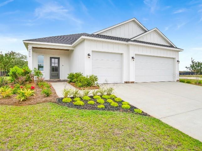 A white, single-story house with a two-car garage and a front porch — 28 WOOD ACRE LANE, PALM COAST, FL