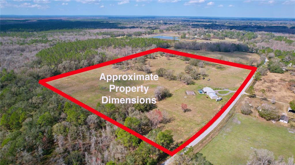 A light green single-story house with a front porch and a gravel driveway — 14890 CR 757, WEBSTER, FL