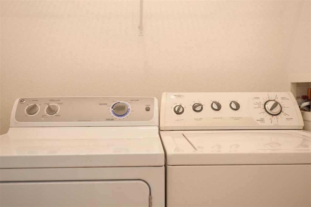 A white clothes dryer and washing machine sit side-by-side in a laundry room — 969 ANDALUSIA LOOP, DAVENPORT, FL