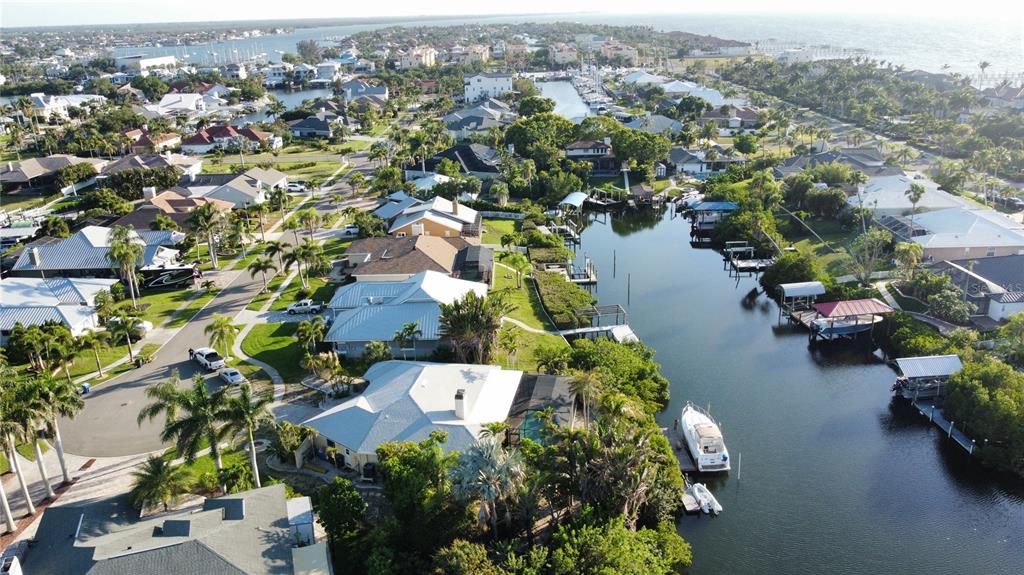 An aerial view shows waterfront homes with private docks along a canal near the coast — 6612 BLACKFIN WAY, APOLLO BEACH, FL