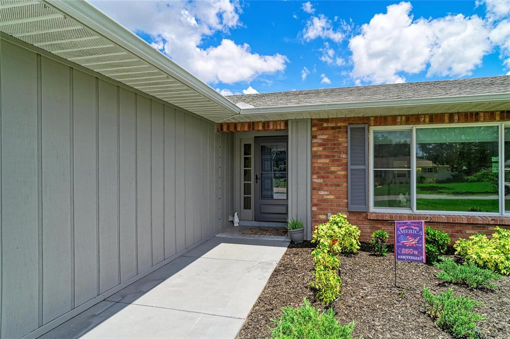 The exterior of a house features a brick facade, vertical siding, and a front entryway — 2011 37TH STREET W, BRADENTON, FL