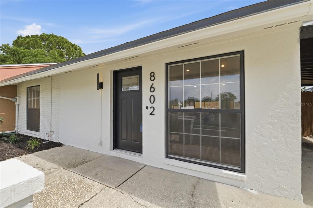 A kitchen features white cabinets, a green slatted island, and a sliding door to a patio — 8602 BRIAR GROVE CIR, TAMPA, FL