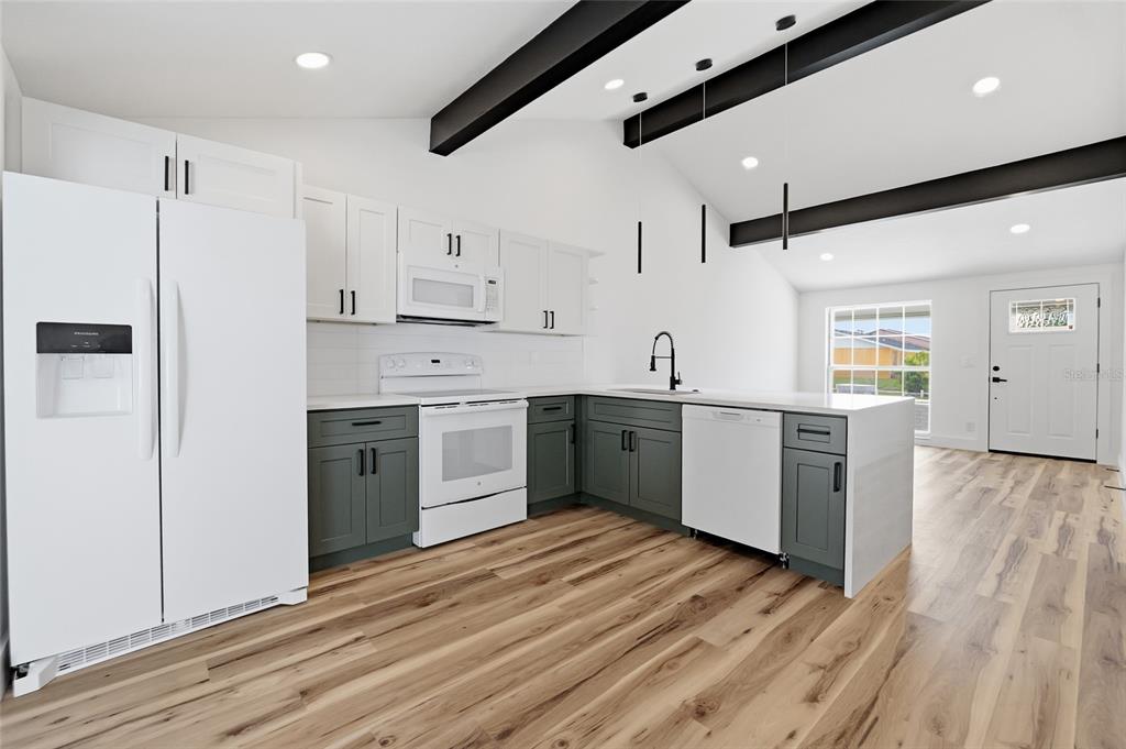 A modern bathroom features a light wood vanity, white countertop, large mirror, and shower-tub combo — 8602 BRIAR GROVE CIR, TAMPA, FL