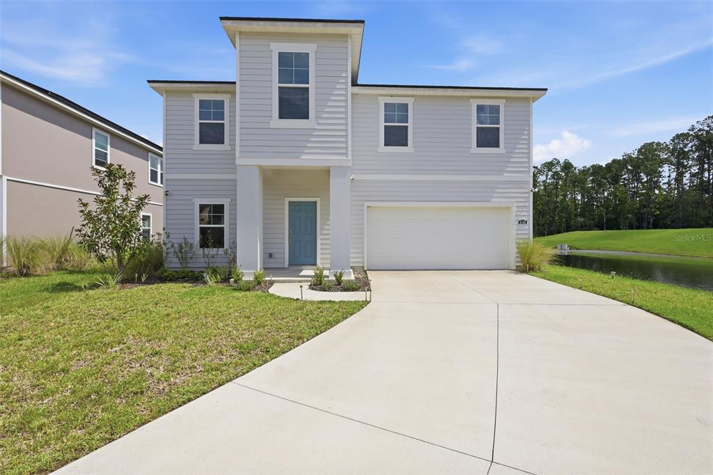 A two-story house with light gray siding, a blue front door, and a two-car garage — 4768 ARGAND DRIVE, JACKSONVILLE, FL