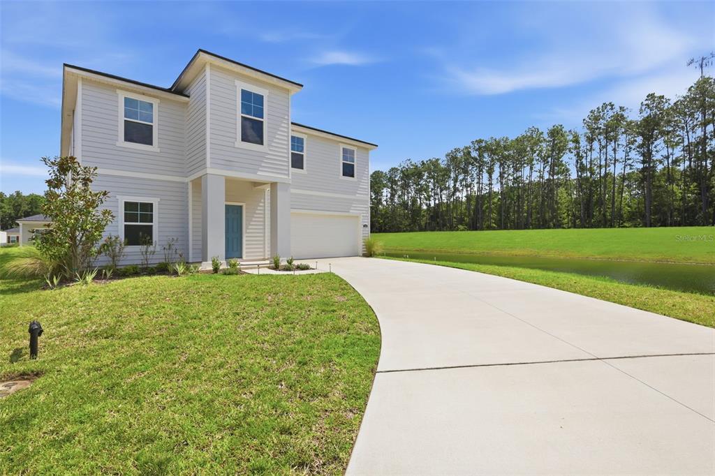 A two-story house with light siding, a two-car garage, and a curved concrete driveway — 4768 ARGAND DRIVE, JACKSONVILLE, FL