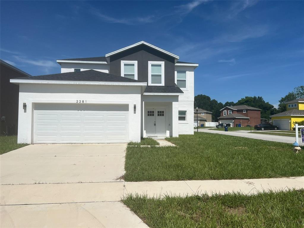 A two-story house with a white stucco facade, dark roof, and a two-car garage — 2281 WHITLEY LANE, WINTER HAVEN, FL