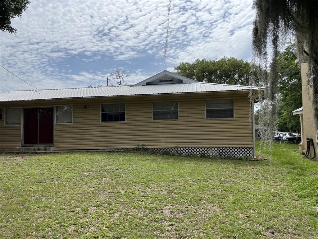 A two-story stucco building features an exterior staircase leading to an upper-level balcony — 818 NE 9TH AVENUE, OCALA, FL