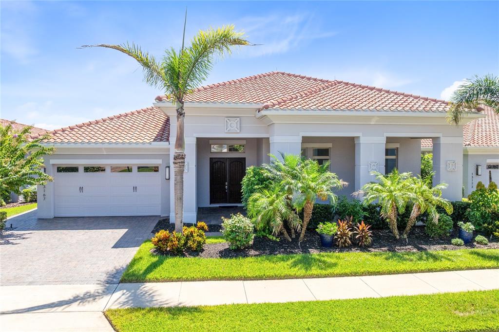 A single-story house with a tiled roof, palm trees, and a paved driveway — 13167 ALDERLEY DRIVE, ORLANDO, FL