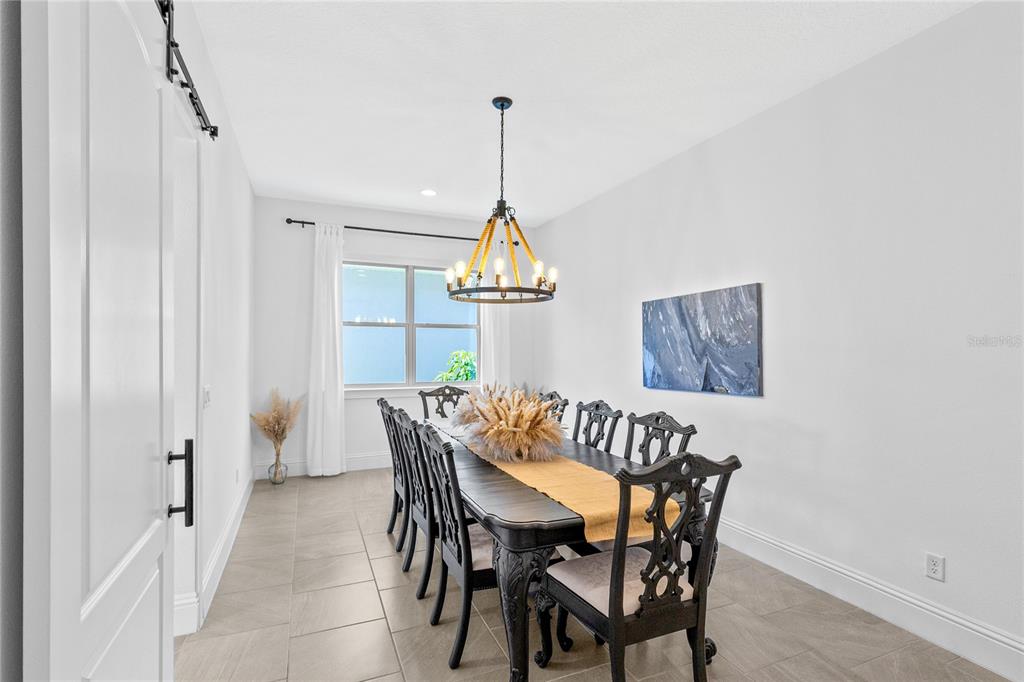 A dining room features a dark wood table, ornate chairs, a rope chandelier, and tile flooring — 13167 ALDERLEY DRIVE, ORLANDO, FL